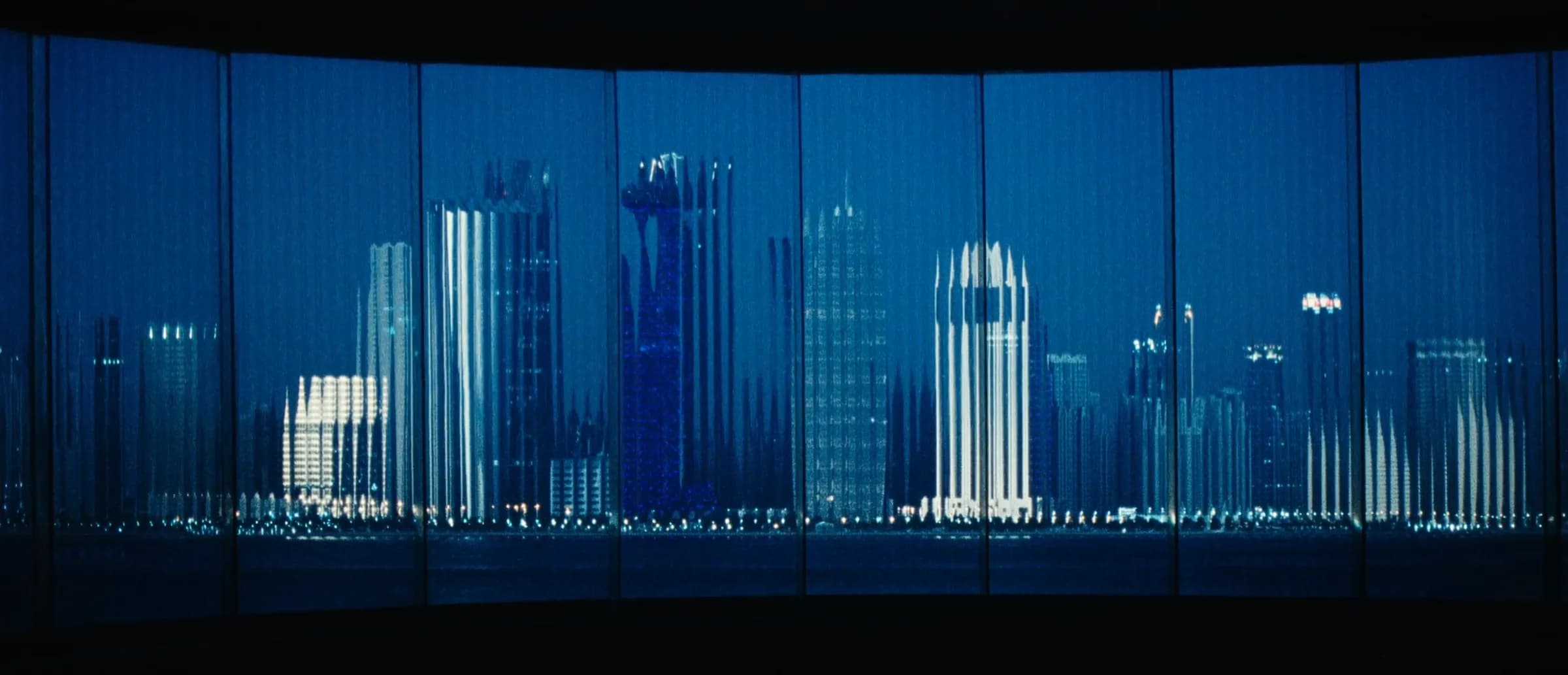 The Doha West Bay skyline at night, seen through fluted glass